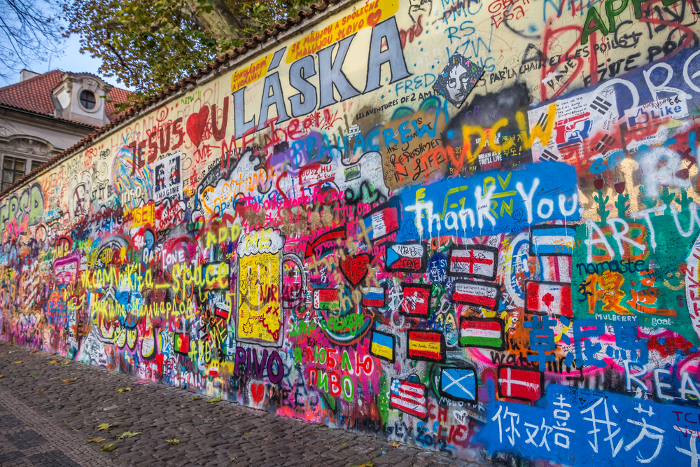 The John Lennon Wall with colorful graffiti in many languages.