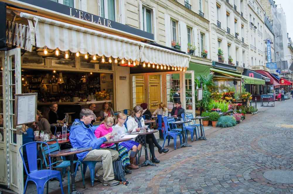 People sitting outside of a cafe on Rue Cler during 4 days in Paris.