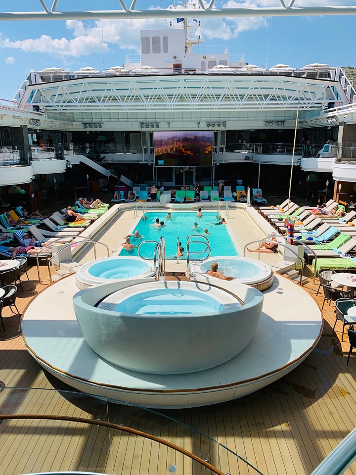 Holland America Mediterranean Cruise Adult Family pool with lounge chairs and people swimming in the pool.