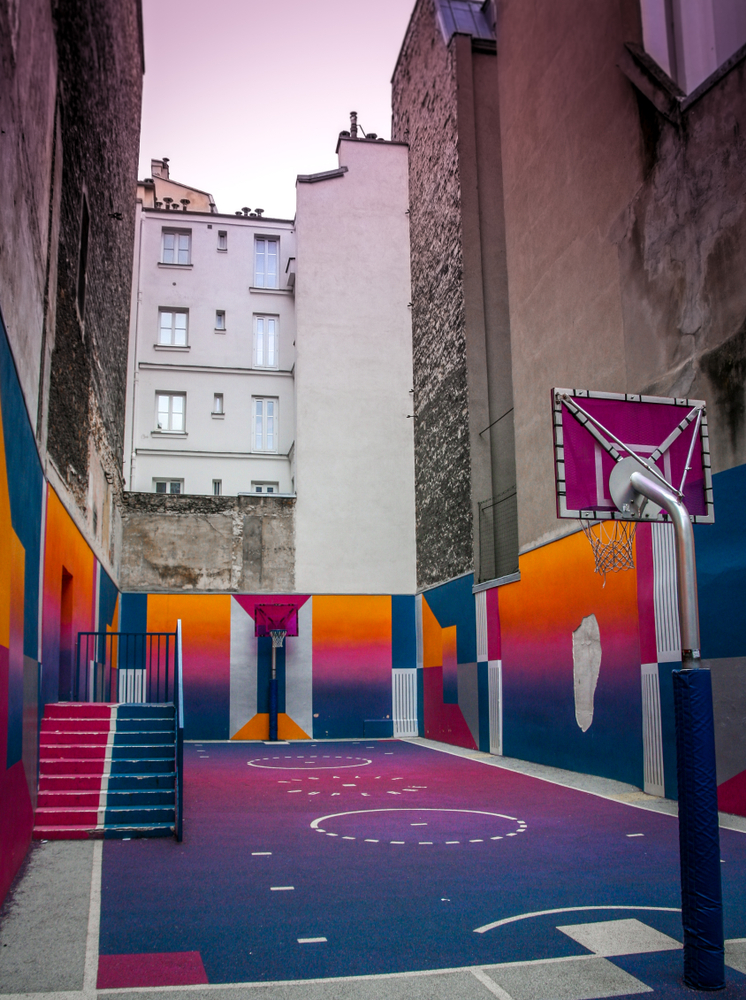 Colorful Pigalle Basketball Court among tall buildings.