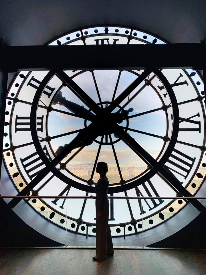 Silhuette of a woman in front of the glass clock in Musee d' Orsay