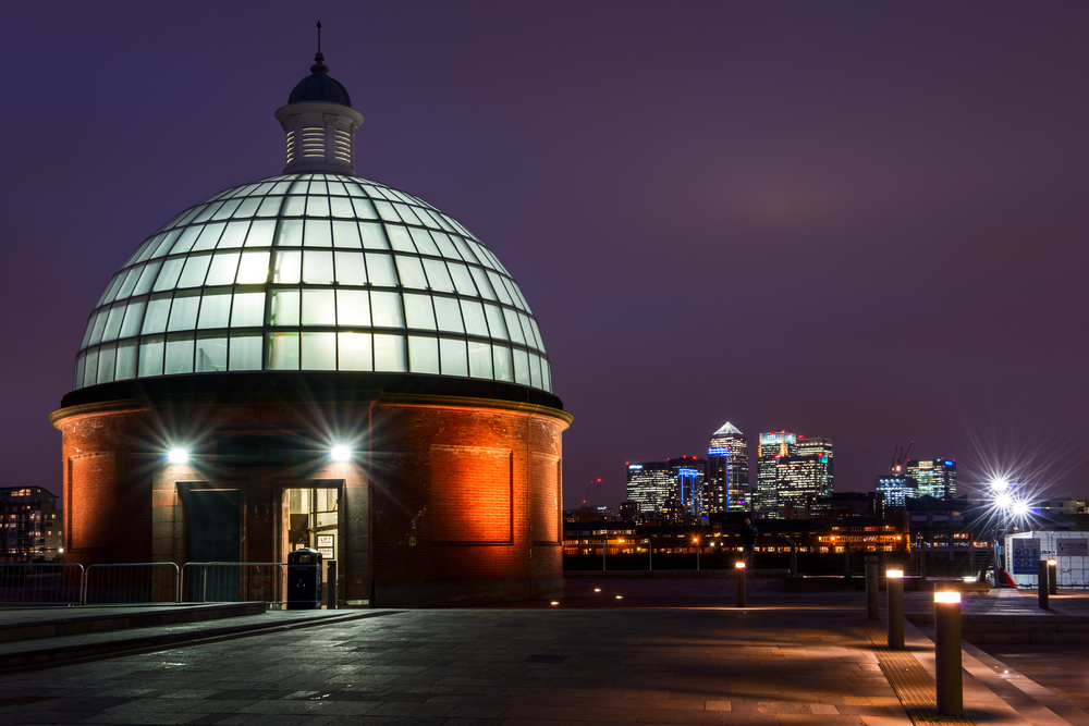 Lighted glass dome leading to the Greenwich Foot Tunnel at night.