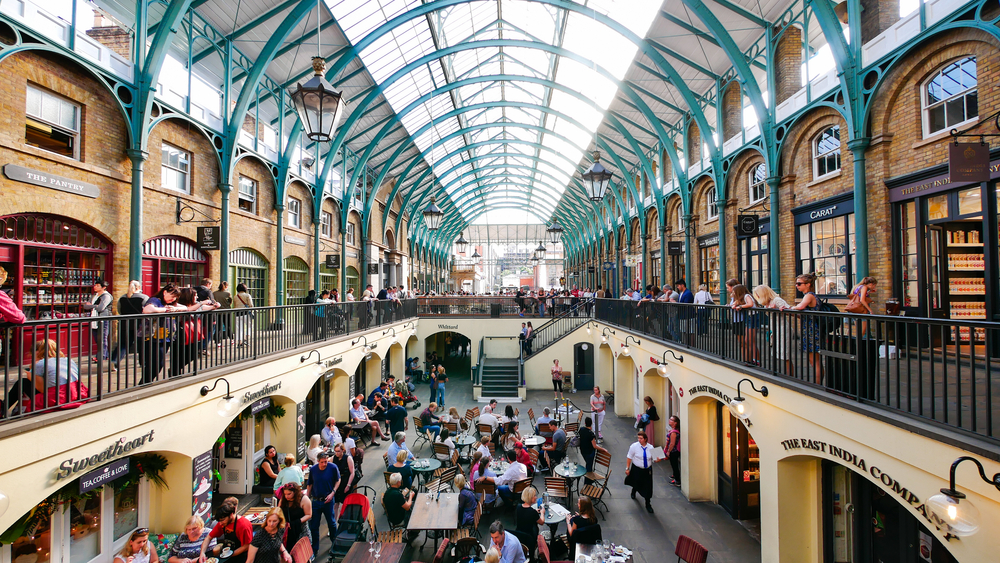 View from the upper level of Covent Garden with people dining below and a glass ceiling above