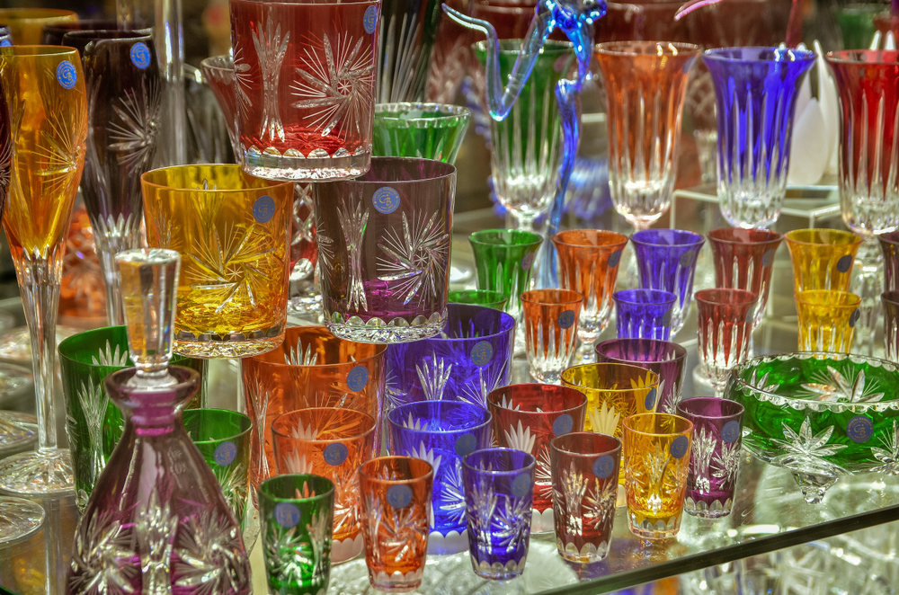 Colorful and detailed Bohemian crystal glasses glitter on the shelves in Prague.