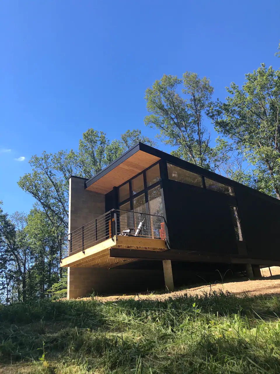 Modern house high up on hill with large glass windows.