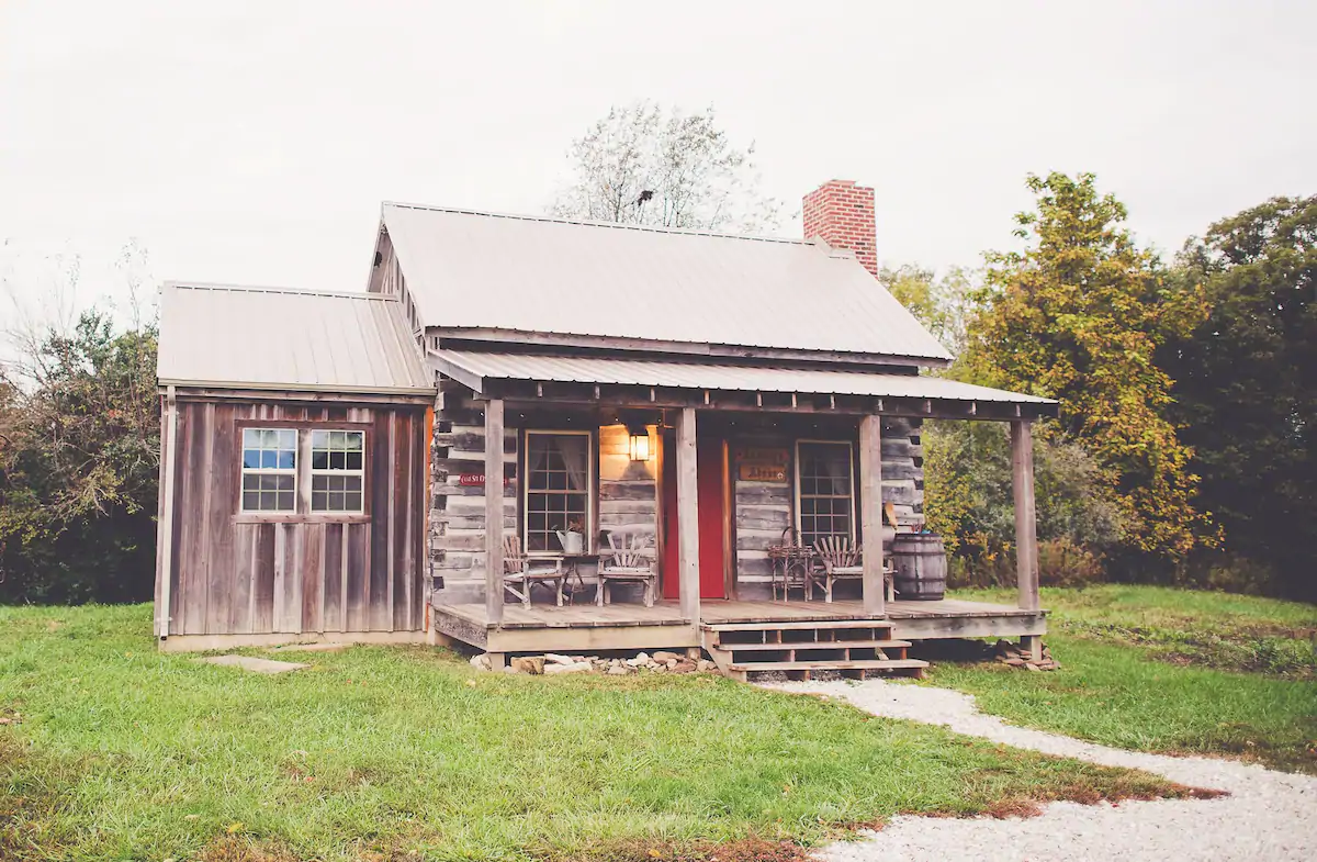 Photo of quaint rustic cabin, with red door. This is one of the best Airbnbs in Illinois.