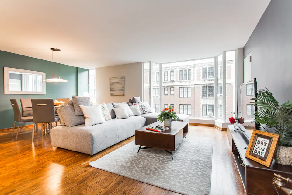 Photo of beautiful living room with gleaming floor to ceiling windows un urban setting