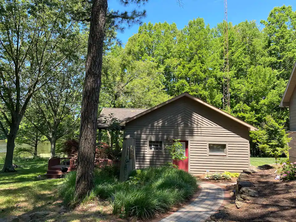 Photo of shaded cabin surrounded by beautiful green trees.