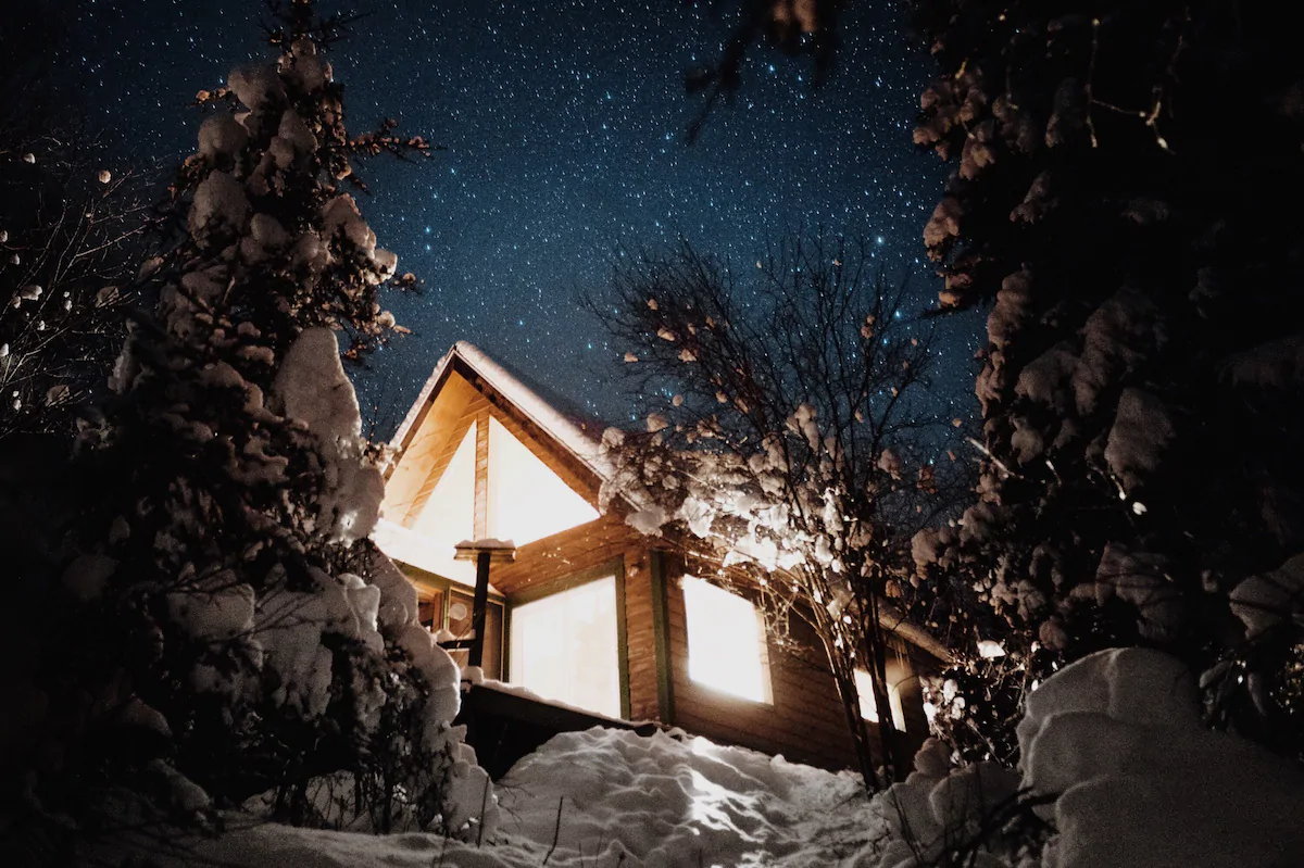 Wintery photo of brightly lit fairytale castle in the night with stars in the sky