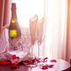 Photo of charming hotel scene with champagne and roses on a table with sunlight streaming in