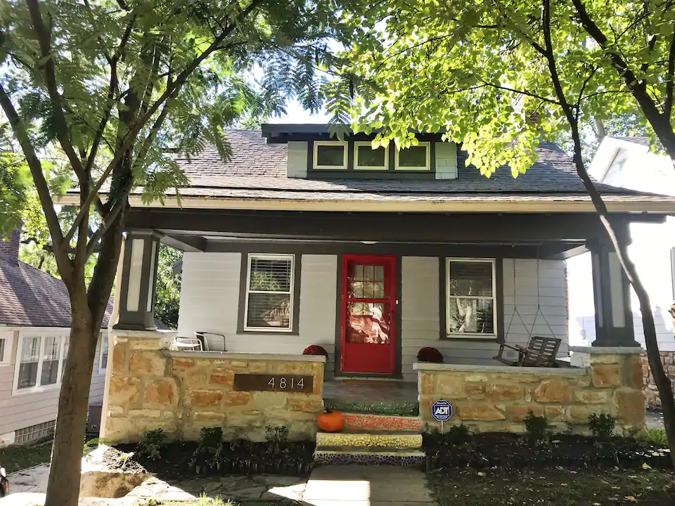 Photo of charming bungalow with red front door, definitely one of the best Airbnbs in Kansas City Missouri