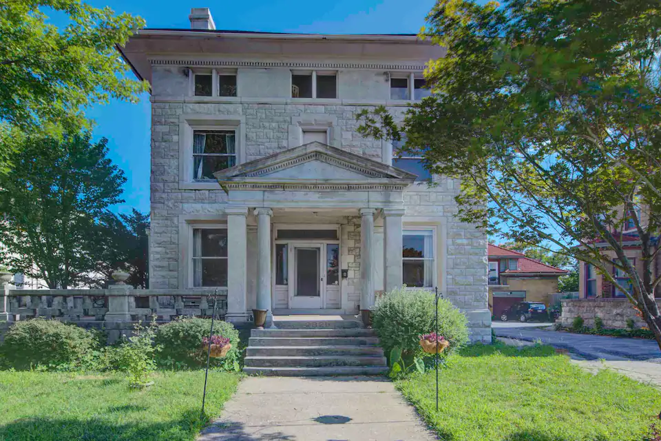 Beautiful three story white stone home with lovely front yard. One of the best Airbnbs in Kansas City Missouri.