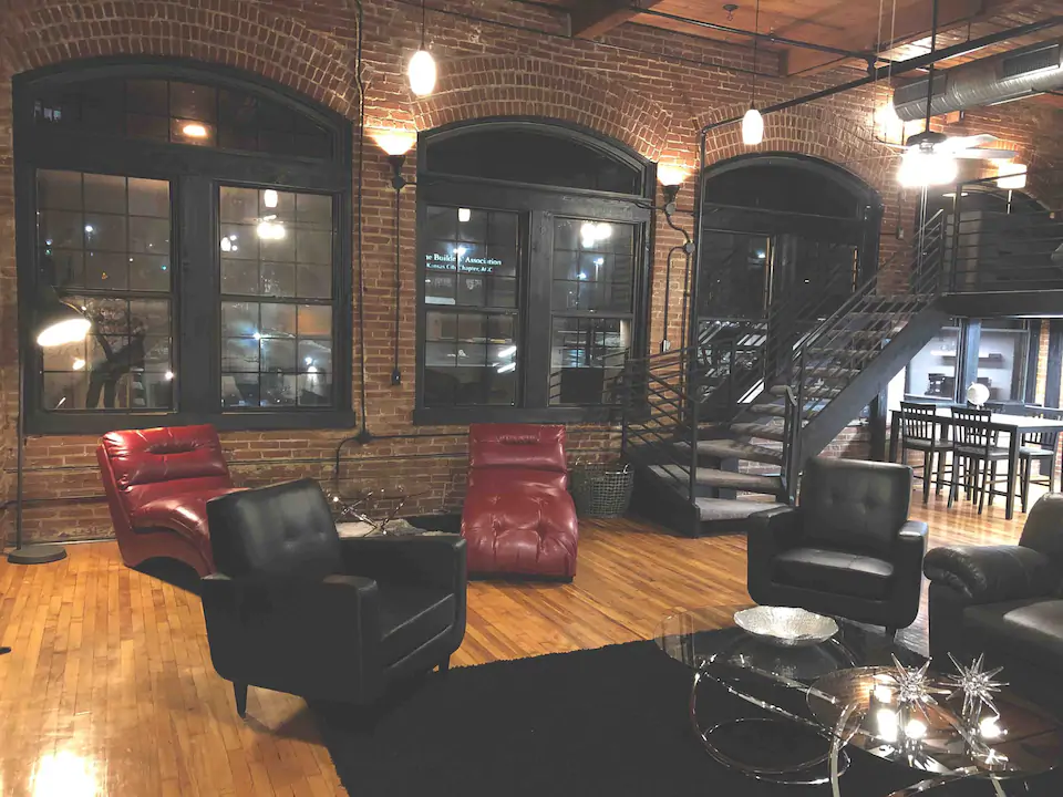 Handsome living room with exposed brick walls and exquisite oversized furniture makes this one of the best lifts in Kansas City MO for rent.