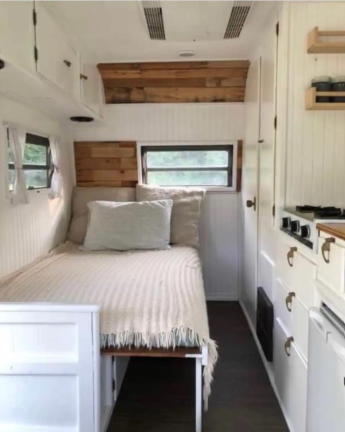 Inside view of the '69 Camper which has a small double bed and kitchenette area glamping in Ohio