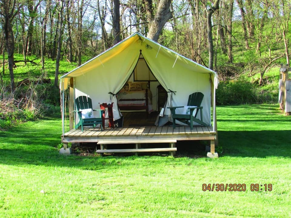 Unique opportunity to glamp in this tent with front deck with chairs to relax in.