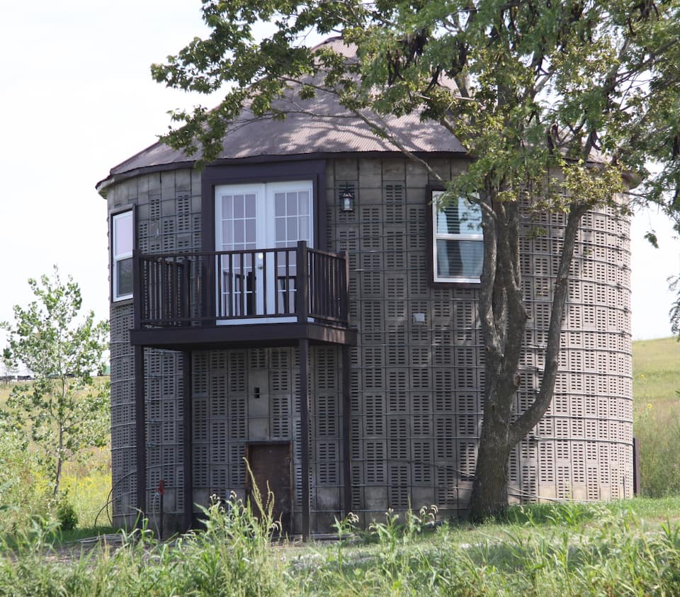 Brown circular corn crib with balcony, now a cabin in Nebraska.