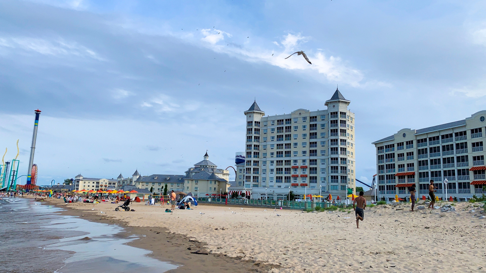 A large sandy beach with tall condos and the Cedar Point Amusement Park behind it