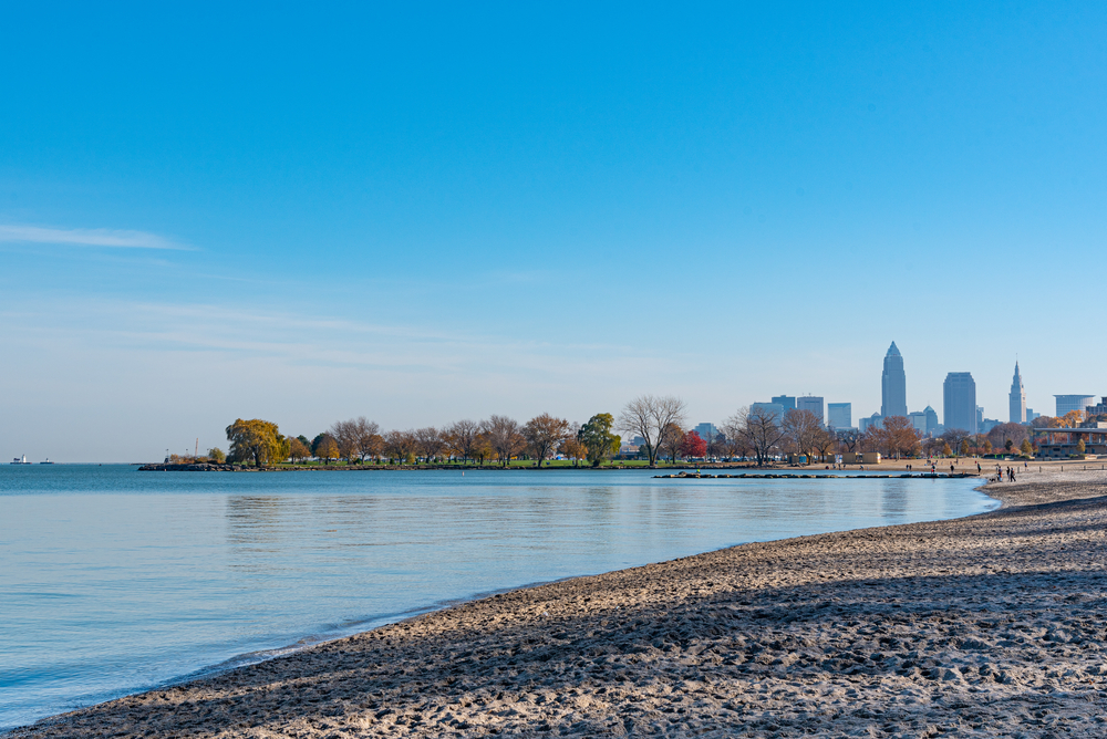 An empty beach with a view of the Cleveland city skyline behind it