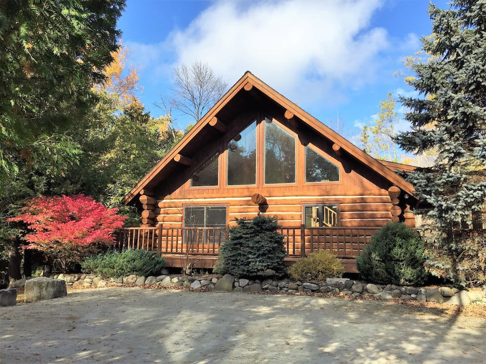 Beautiful Wisconsin log cabin rental with large windows and surrounded by beautiful landscaping.