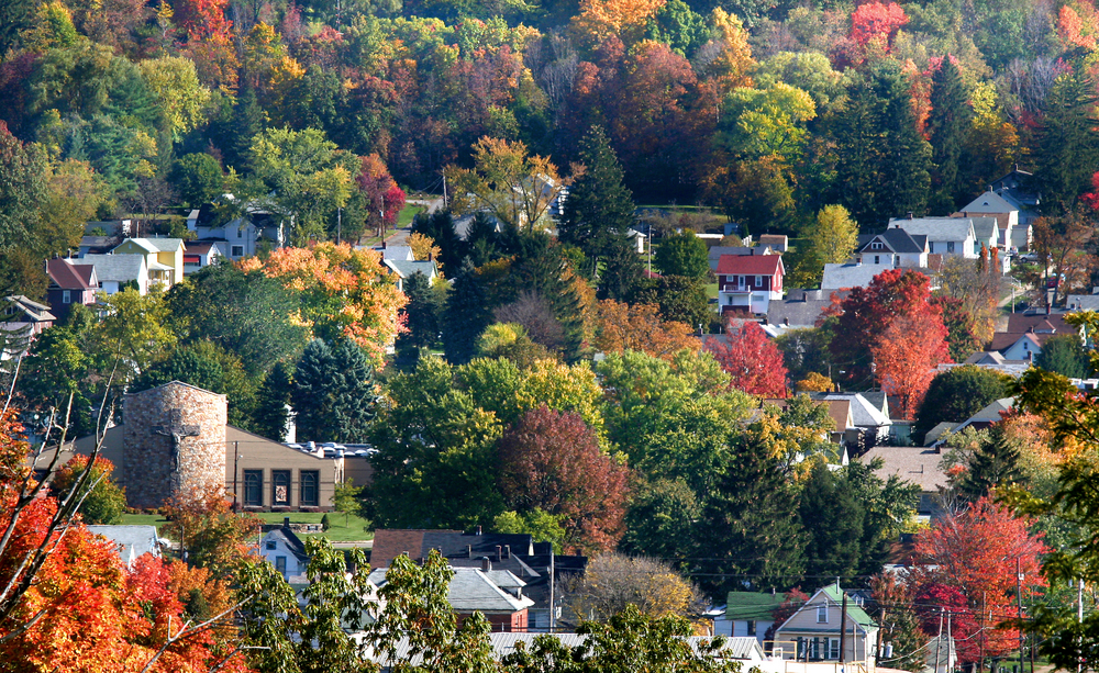 Small hillside town in Pennsylvania nestled between trees bright with autumn colors.