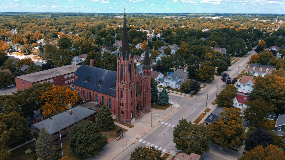 An aerial view of the town of Austin Minnesota featuring a very large gothic style brick church