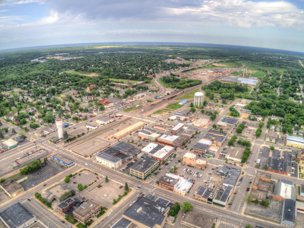An aerial view of the main district of Brainerd Minnesota in the summer with large patches of green trees around it