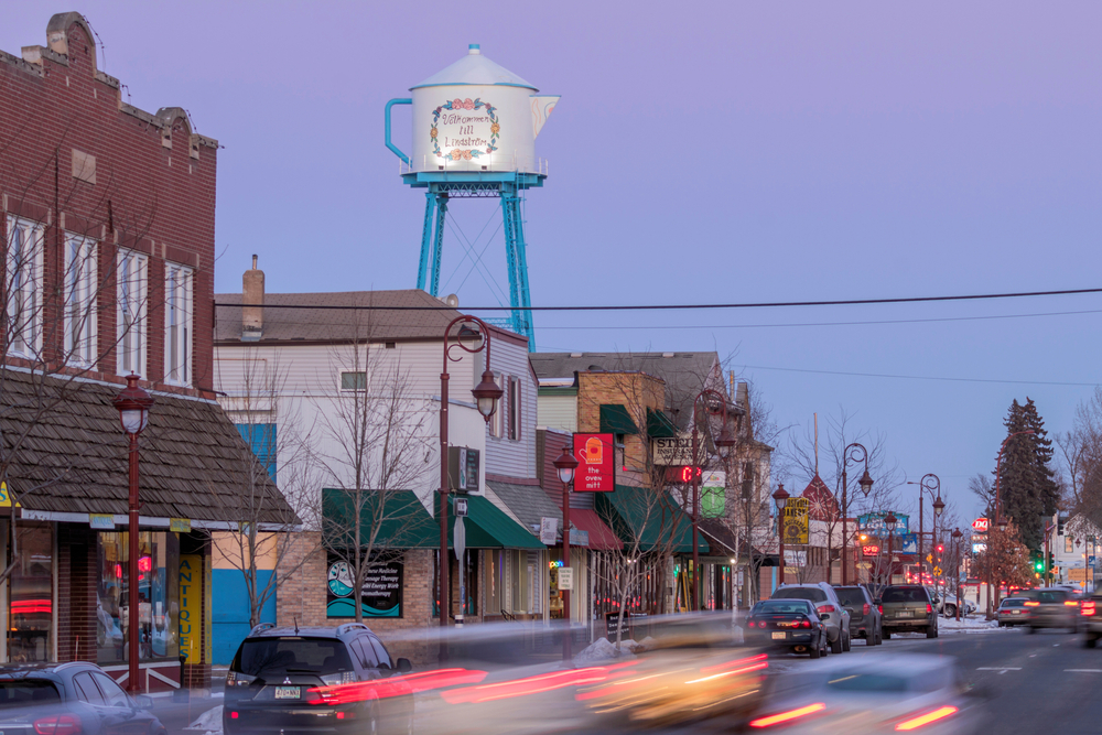The main street of Lindstrom Minnesota at twilight with the water tower shaped like a tea kettle in the background