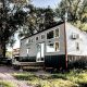 a gray and black tiny home in Nebraska surrounded by grass and trees