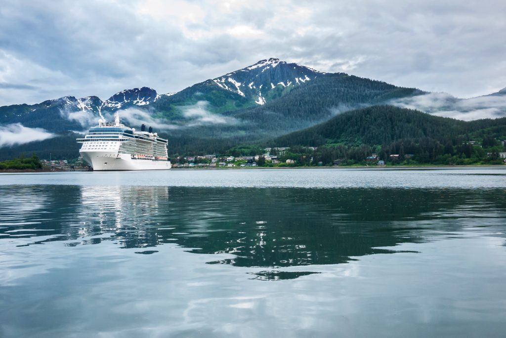 Alaska cruise ship in port with blue waters and snow capped mountains in background.