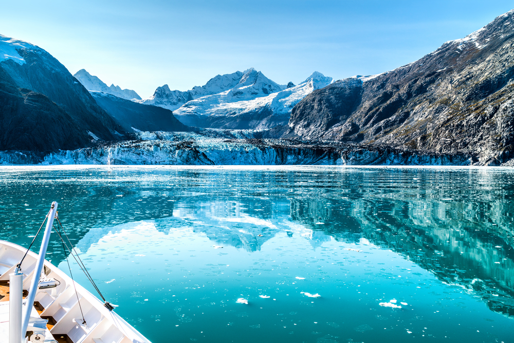 Front of Alaska cruise ship pointing towards glacier and mountains.