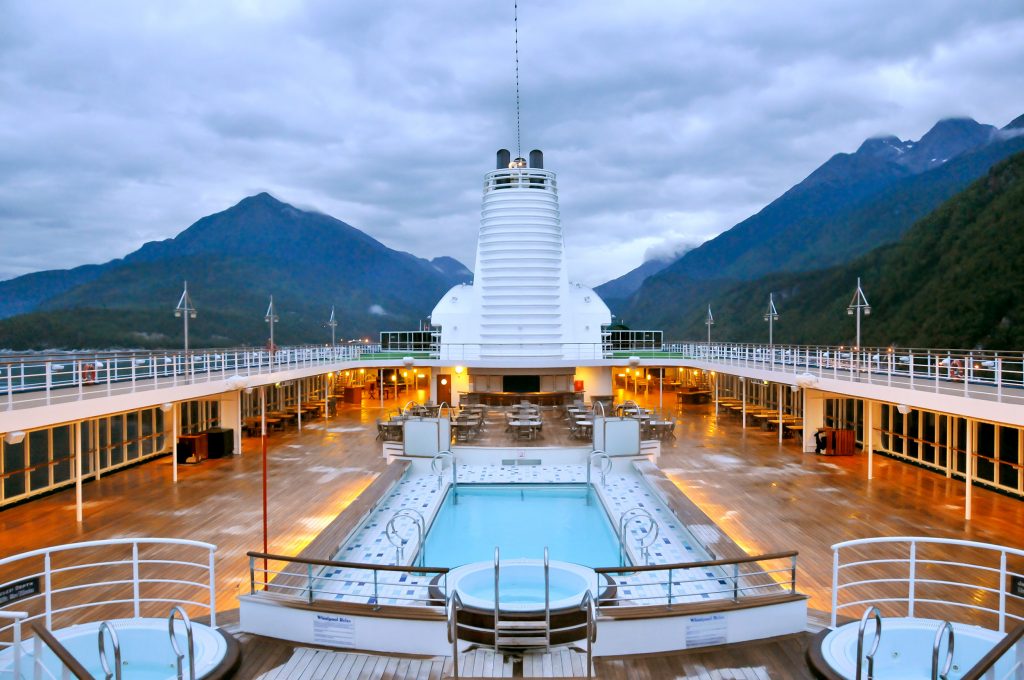 Pool deck on Alaska cruise surrounded by mountains.