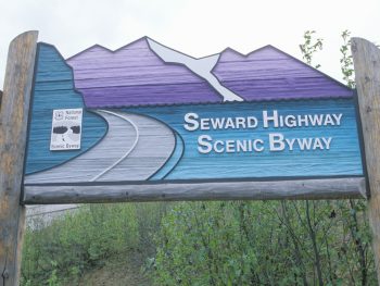 Blue and purple Alaska road sign signaling Anchorage to Seward