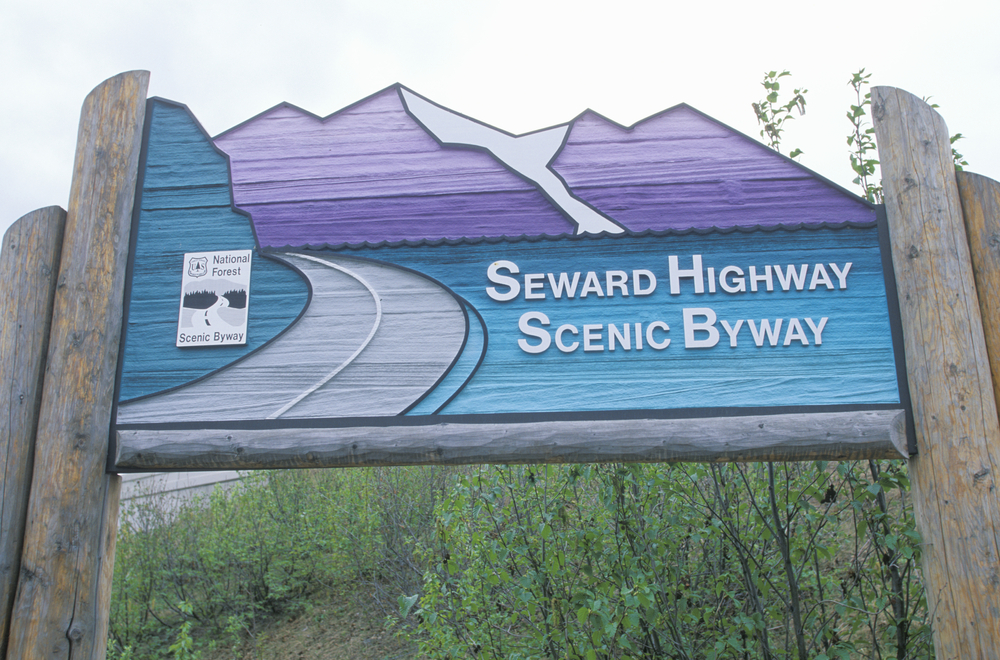 Blue and purple Alaska road sign signaling Anchorage to Seward