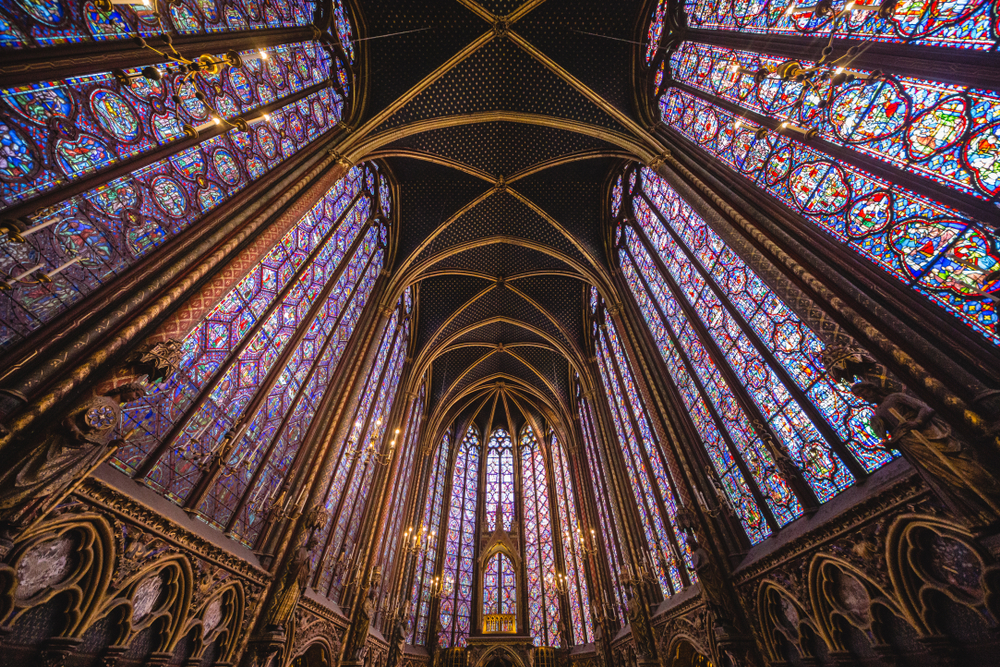 Brilliant panels of stained glass windows to ceiling separated by ornate gold columns. 4 days in Paris itinerary