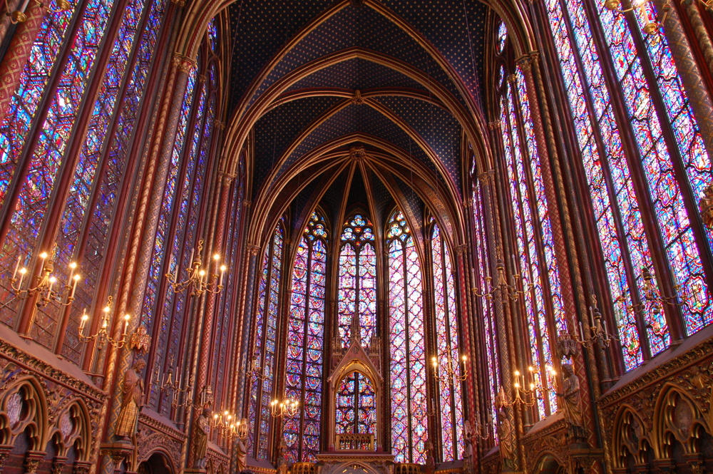 Stained glass windows to ceiling with golden details and gold, lit candelabras during 2 days in Paris.