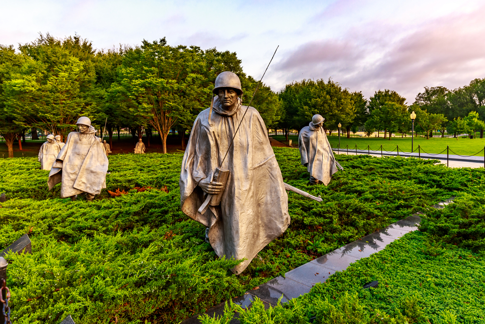 The statues at the Korean War Veterans Memorial at sunset in green shrubbery. One of the inspiring places to visit in Washington DC
