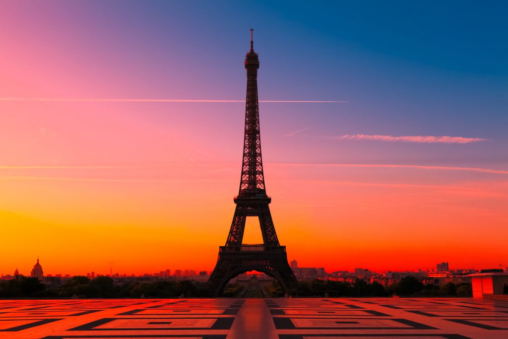 Iron Eiffel Tower with orange red sunset sky in background with ornate tiles in foreground. 3 days in Paris itinerary for sure.