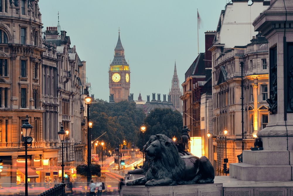 Dusk over London with Big Ben and the lions of Trafalgar Square.