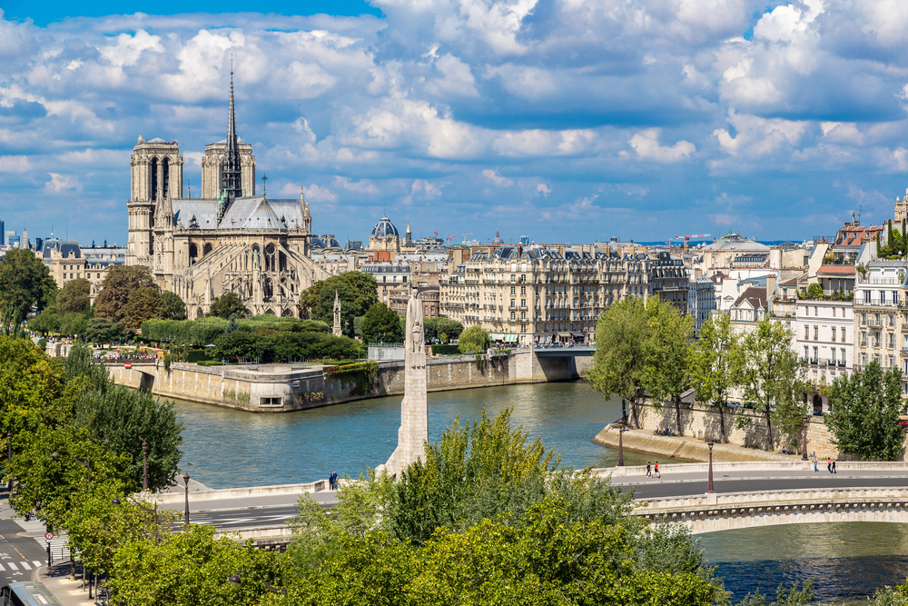 View of a bridge over the Seine River with Notre Dame in the distance.