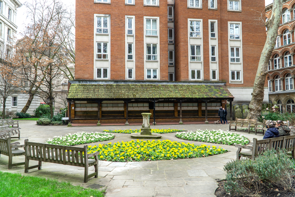 Postman's Park with flowers and a memorial.