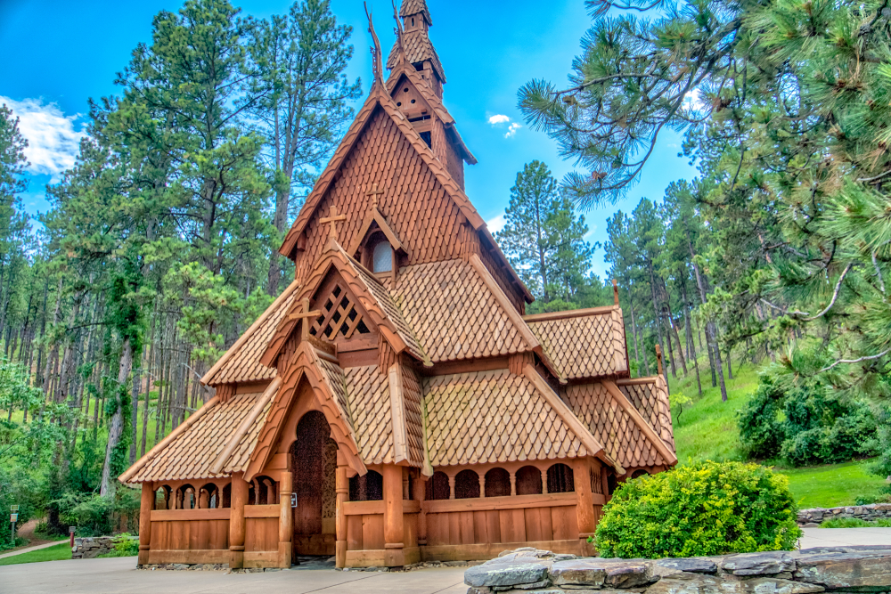 Beautiful wooden brown wooden church in hills surrounded by green trees. 