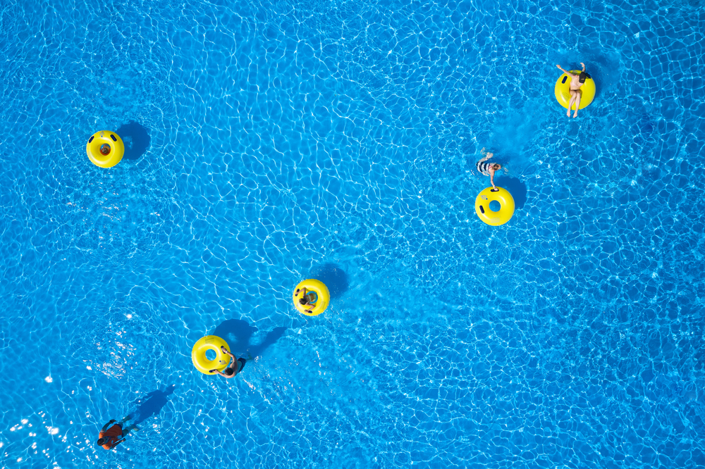 People in yellow floaties in bright blue waters at Rapid City waterpark.