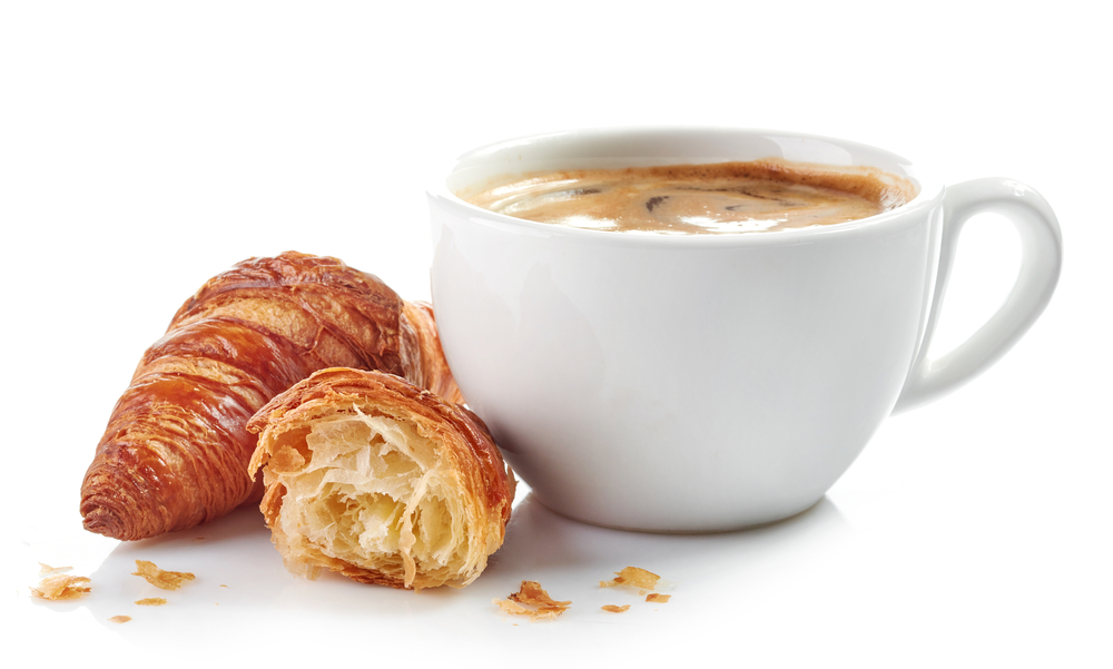 cup of coffee and croissants isolated on white background. In an article about breakfast in Amsterdam