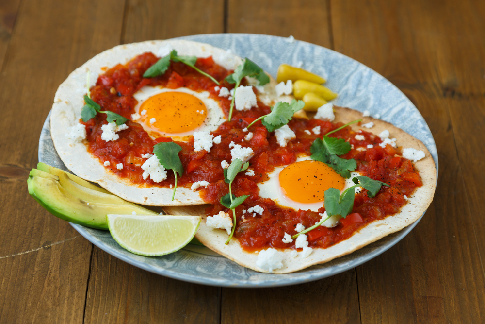 Breakfast with fried egg and sauce on grilled flour tortilla, Mexican dish huevos rancheros.  