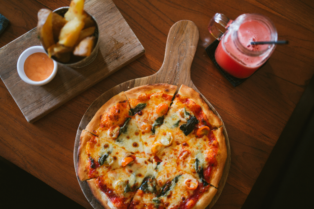 Woodfired Margherita Pizza on a table with drinks in an article abput restuarants in Dublin