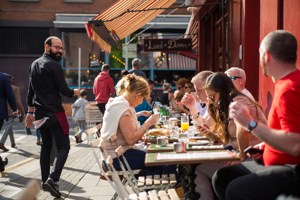 People having lunch outside in the sun. The article si about restuarants in Dubin