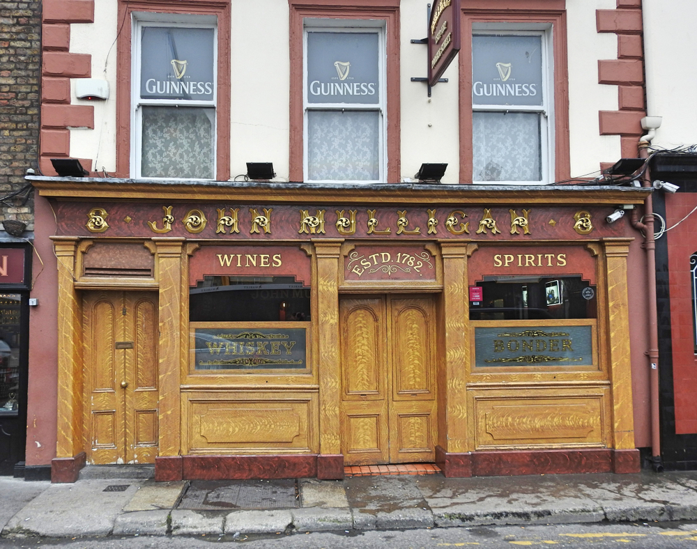 The front exterior of Mulligan's with wood paneling and ornate lettering, one of the best pubs in Dublin