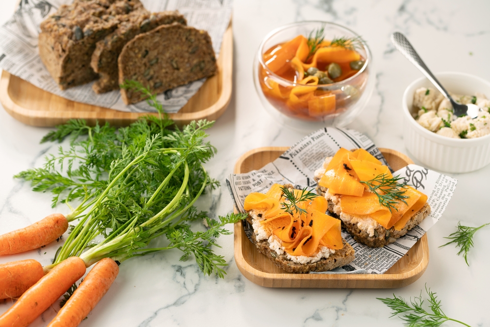 healthy vegan homemade carrot lox sandwiches with accompaniments around it. 