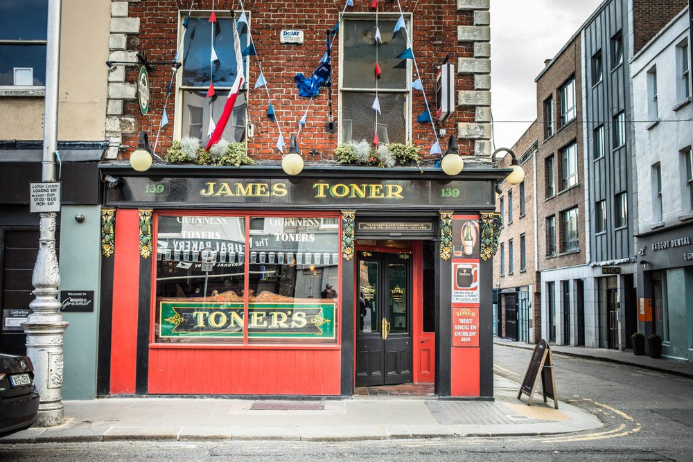 The exterior of Toners, a pub in Dublin, that is painted red and black with green accents
