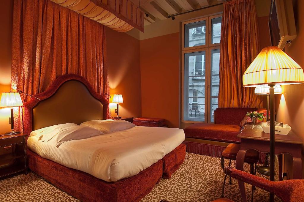 Rust coloured hotel bedroom with a large bed and luxurious fixtures and fittings. 